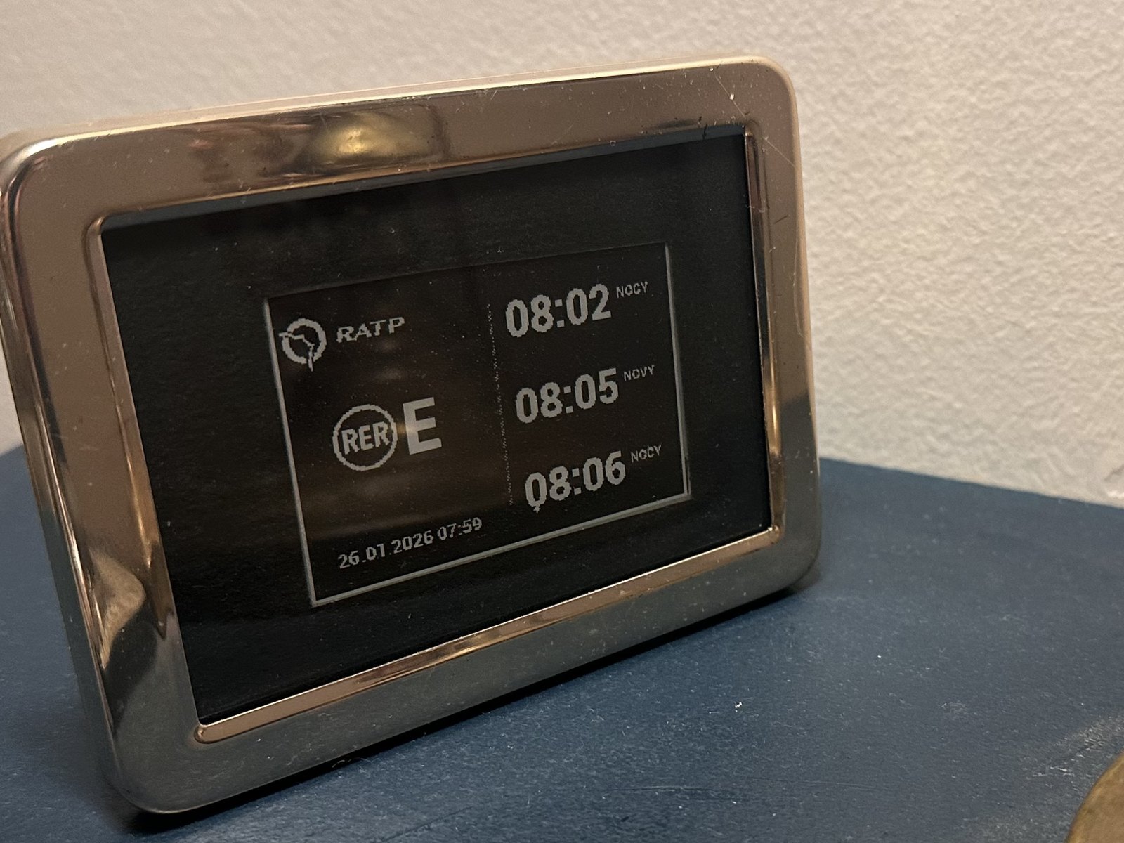 Cadre chromé affichant les prochains passages du RER E.